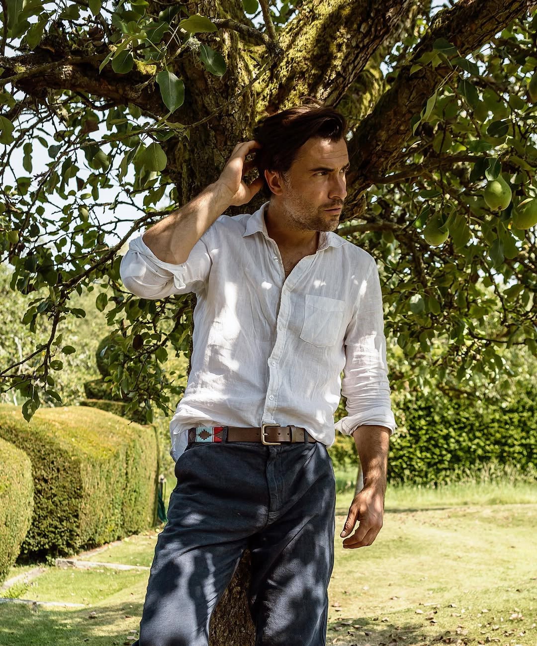 A man standing and wearing brown polo leather belt